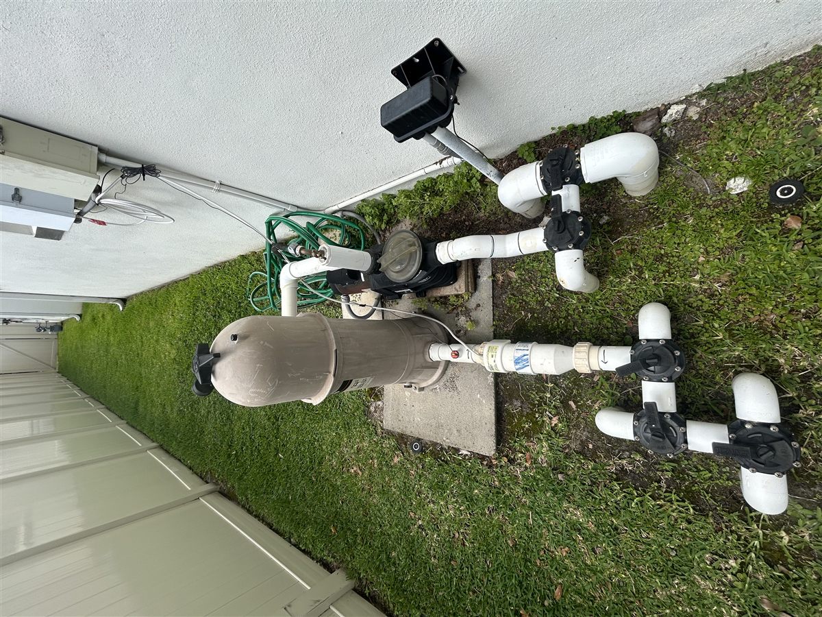 Example wide photo of a pool equipment pad showing filter, pump, valves, and plumbing